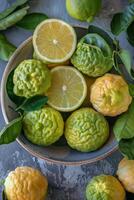A bowl of lemons and limes with leaves photo