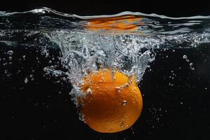 An orange is falling into the water photo