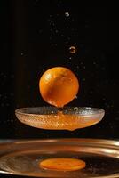 Orange falling from a plate into a bowl photo