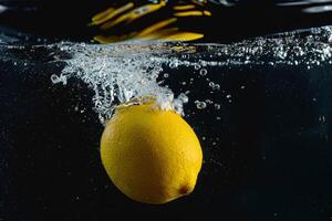 A lemon is being splashed into the water photo