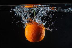 An orange is falling into water photo