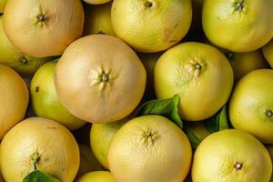 A pile of yellow lemons with green leaves photo