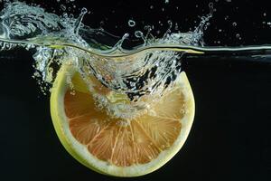 A slice of lemon is being splashed into the water photo
