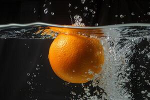 An orange is being splashed in water photo