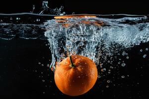 An orange is being dropped into water photo