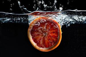 An orange slice is being splashed into water photo