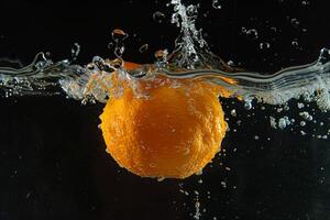 An orange being splashed in water photo