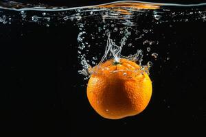 An orange is being dropped into water photo
