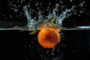 An orange is falling into water photo