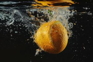 An orange is being splashed into the water photo