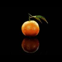 A single orange on a black surface photo