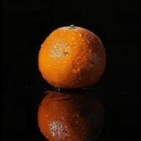 A single orange on a black surface photo