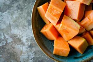 A bowl of sliced melon sitting on a table photo