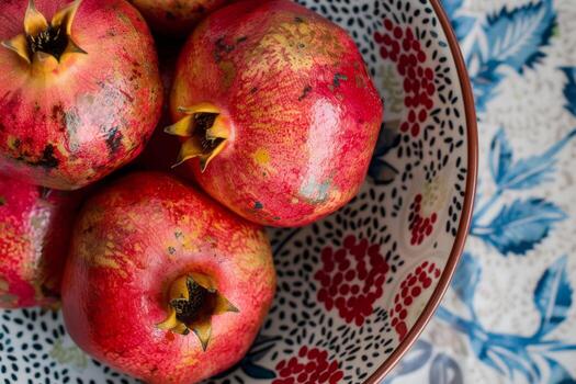 A bowl of pomegranates sitting on a table photo
