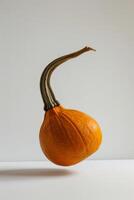 A pumpkin is floating in the air on a white surface photo