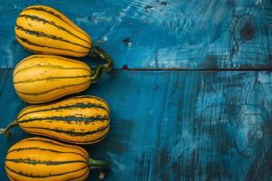 Three yellow squash on a blue wooden table photo
