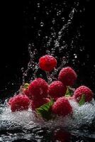 Raspberries being splashed with water on a black background photo