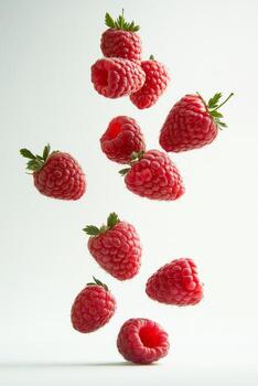 A group of raspberries are falling to the ground photo