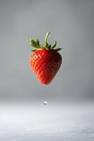 A strawberry is being dropped into water photo