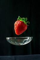 A strawberry floating in a glass bowl photo