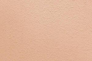 Peach wall of the building. Rough plaster surface. Abstract background. photo