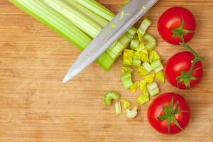 Celery and tomatoes on a cutting board photo