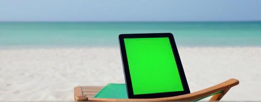 A green screen tablet computer on the beach photo