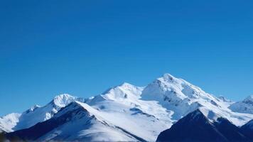 A mountain range with snow capped mountains in the background photo