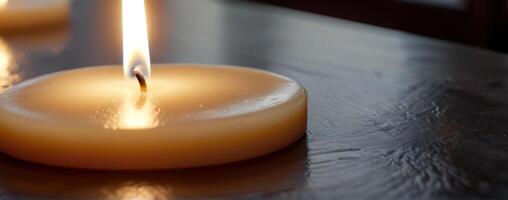 Three candles lit on a wooden table photo