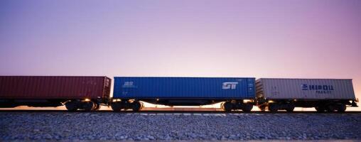 A train with cargo containers on the tracks at sunset photo