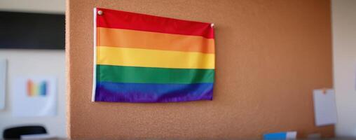 A rainbow flag hangs on the wall of an office photo