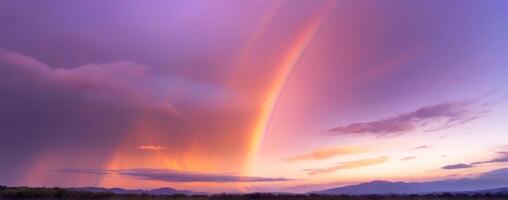 A rainbow is seen over the mountains at sunset photo