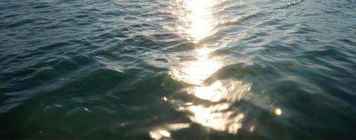 The sun shines through the water on a boat photo