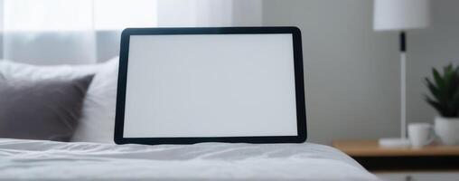 Tablet pc on bed with blank screen photo