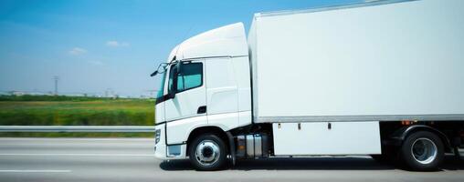 A white semi truck is driving down the road photo