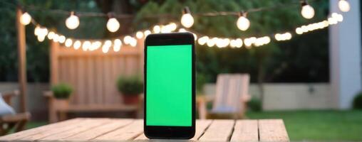 An iphone with a green screen sitting on top of an outdoor table photo