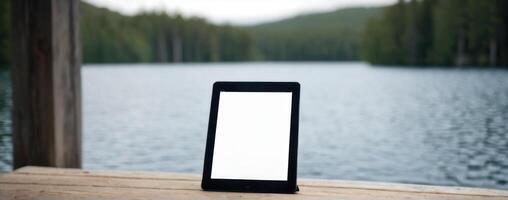 A tablet computer sitting on the edge of the lake photo