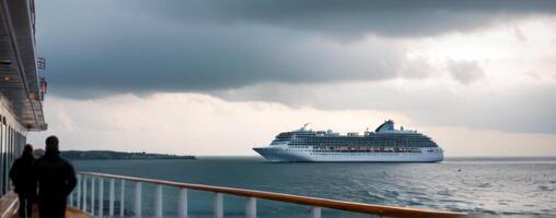 A cruise ship in the ocean with people standing on the deck photo