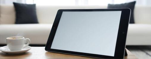 An ipad tablet on a wooden table with coffee photo