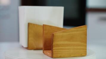 Wooden napkin holder with paper serviettes rotate on kitchen table. Space for text video