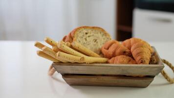 Homemade bread sticks, croissant and fresh toaster bread in a wooden basket video