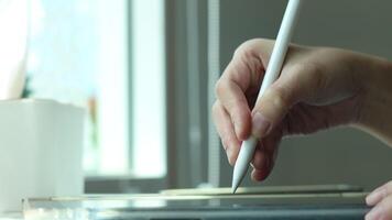 Hand using digital stylus writing on tablet. Concept of digital signature Signing documents electronically via tablet or taking notes electronic video