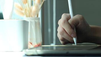 Hand using digital stylus writing on tablet. Concept of digital signature Signing documents electronically via tablet or taking notes electronic video