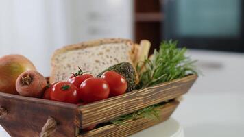 Wooden basket with fresh vegetables, cheese bread sticks and fresh toaster bread rotate in kitchen video