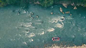 Aerial view on top Rafting rafting on a mountain river. View from above on a red boat with people overcoming obstacles and rocks on a steep mountain river. video