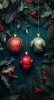 Festive holiday ornaments hanging among evergreen branches and berries on a blue backdrop photo