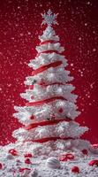 Beautifully decorated artificial Christmas tree in a festive red and white setting with snowflakes photo