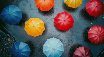 Colorful umbrellas arranged on a wet pavement in a vibrant urban area during a rainy day photo
