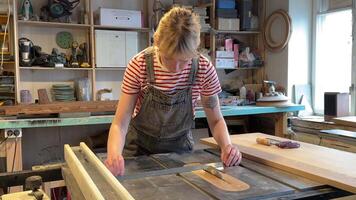 Focused woman carpenter prepares circular saw for use, measuring distance with ruler in workshop video