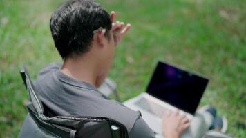 sério homens estão olhando para inspiração para faço decisões, sentir falta do Ideias, trabalhos estresse, trabalhando on-line, ansiedade, trabalhando dentro a parque, escritório síndrome. analisando a gráfico e digitando em computador portátil. video